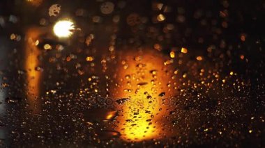 Şiddetli yağmur akşamı sokak büyük şehirde içki alıyor. Yolda araba ıslak cam üzerinden görüntülemek.