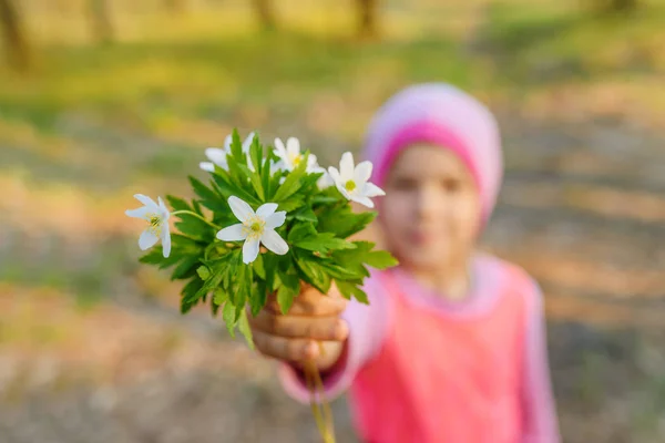 Piccola ragazza sorridente con anemone nemorosa — Foto Stock