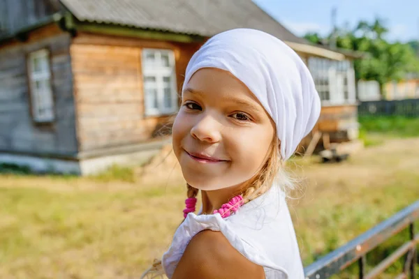 Kırsal house yakınındaki karşı beyaz Fularlı küçük sakin kız