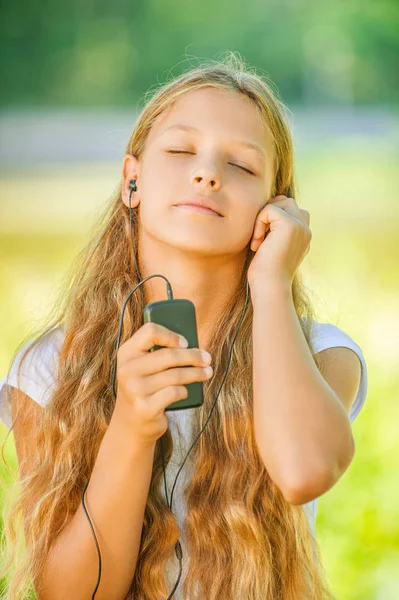 ヘッドフォンの音楽を聴くと 10 代の少女 — ストック写真