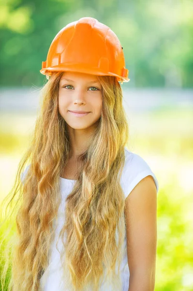 Hermosa adolescente en un casco naranja — Foto de Stock
