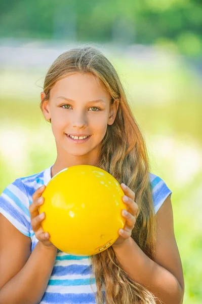 Smiling teenage girl holding yellow ball — Stock Photo, Image