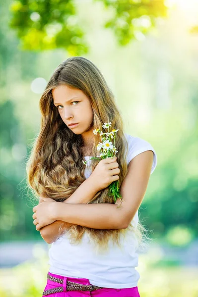フィールドのヒナギクの花束を持つ少女の笑みを浮かべてください。 — ストック写真