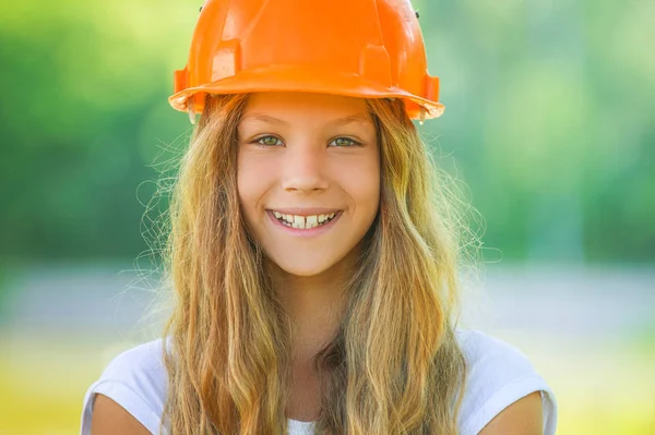 Hermosa adolescente en un casco naranja — Foto de Stock