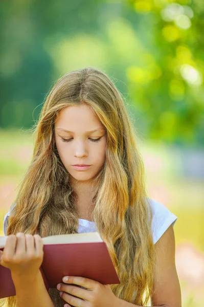 Pretty severe young girl reads red book — Stock Photo, Image