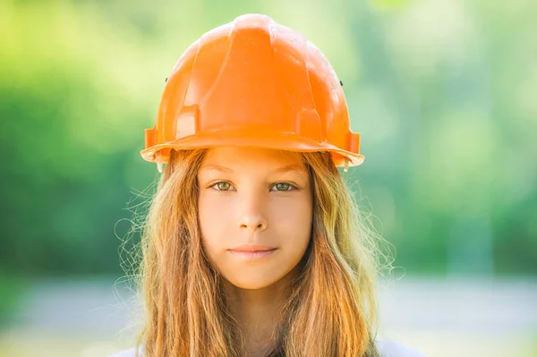 Linda chica joven en un casco de construcción naranja — Foto de Stock