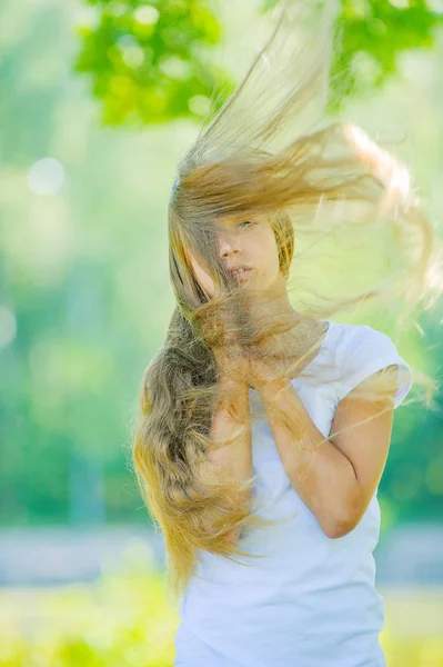 Smiling beautiful teenage wind with flying hair — Stock Photo, Image