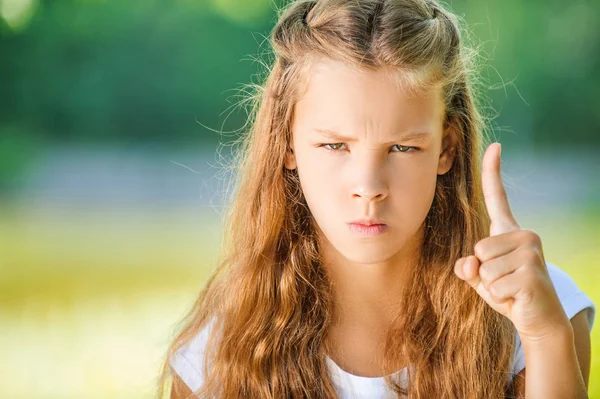 Pretty severe young woman holds up finger — Stock Photo, Image