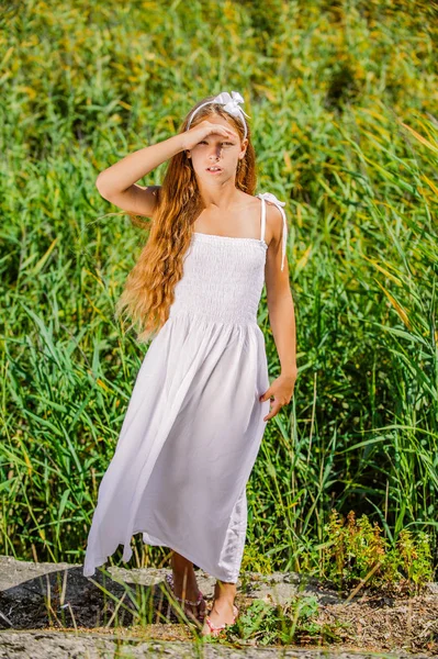 Young girl of hand covers her eyes from sun — Stock Photo, Image