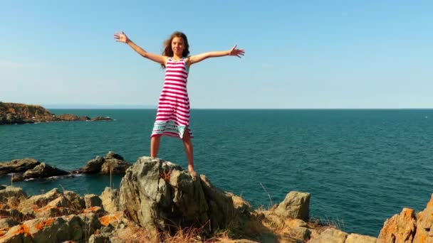 Маленькая красивая девочка на скалистом берегу Средиземного моря . — стоковое видео