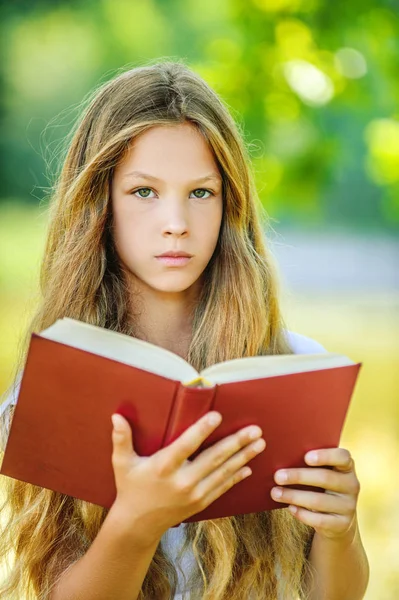 Adolescente chica leyendo rojo libro —  Fotos de Stock