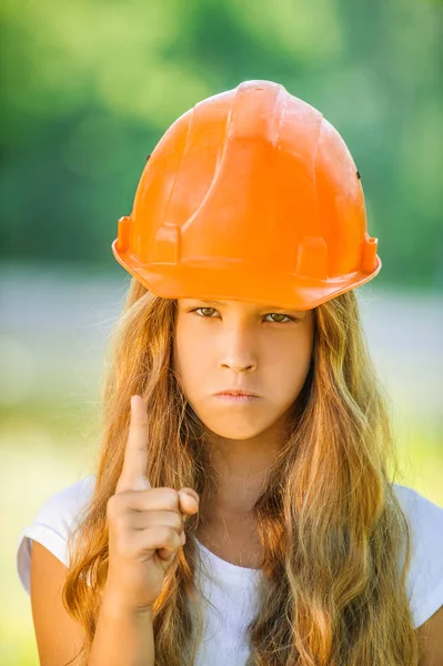 Linda chica joven en un casco de construcción naranja — Foto de Stock