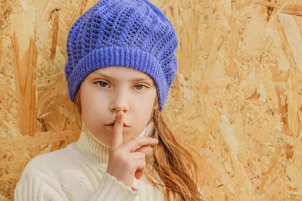 Pequena menina bonita no boné pede silêncio — Fotografia de Stock