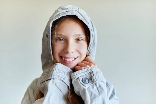 Liten vacker flicka i grå jacka och huva — Stockfoto