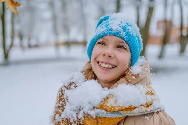 Little smiling girl in blue cap in snow — Stock Photo, Image