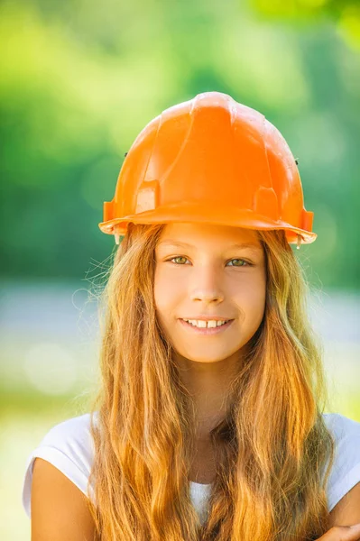 Hermosa adolescente en un casco naranja — Foto de Stock