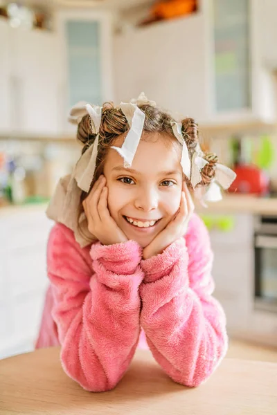 Маленька усміхнена дівчинка з бігунками на голові — стокове фото