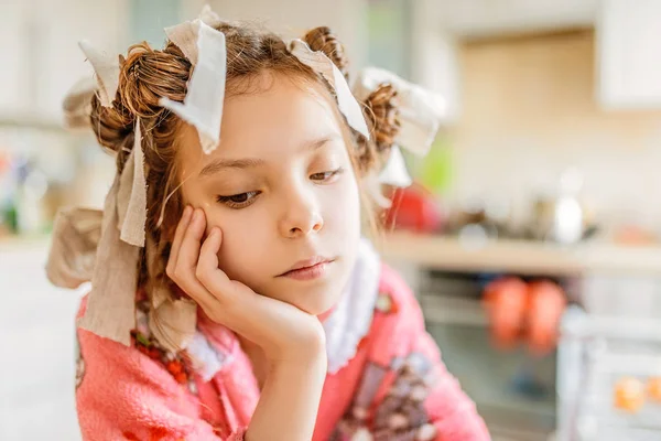 Pequena menina pensativa com encrespadores de cabelo na cabeça — Fotografia de Stock