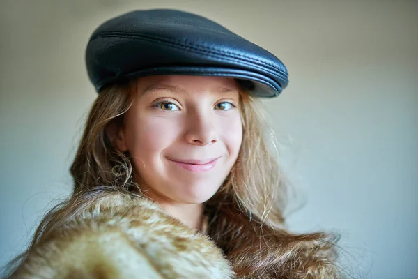 Piccola ragazza sorridente in pelliccia calda e cappuccio nero — Foto Stock