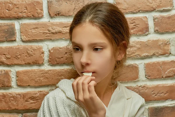 Pequeña chica hermosa cerca de la pared de ladrillo — Foto de Stock