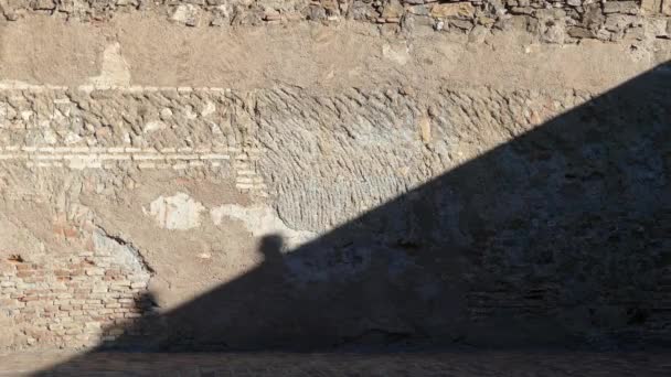 Тени на стене в Алькасар-де-Гибралфаро, это крепость, расположенная в испанском городе Малага. Финикийский вольер содержал маяк, который дал название холму Гибралфаро . — стоковое видео