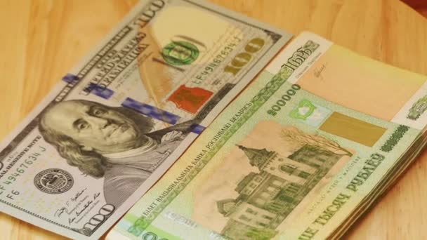 Rublos bielorrussos valor nominal duzentos mil mentira e dólar dos Estados Unidos (dólar americano) na mesa de madeira . — Vídeo de Stock