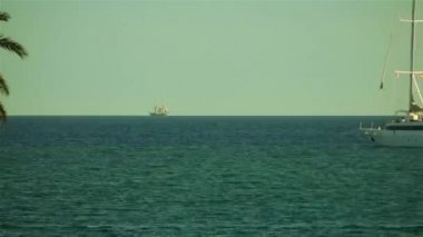 Sakin, sıcak havalarda açık denizde gemiler.