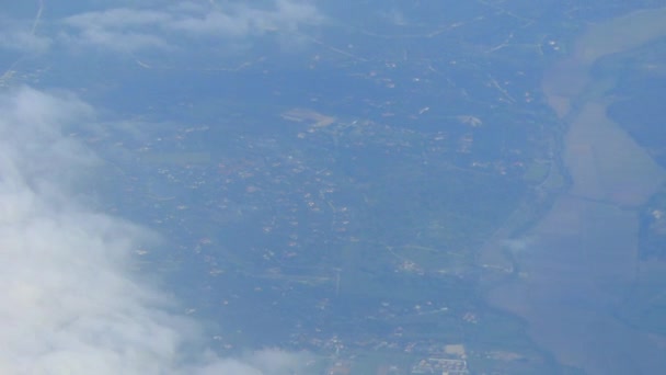 Vue de la terre et des nuages depuis la fenêtre de l'avion .