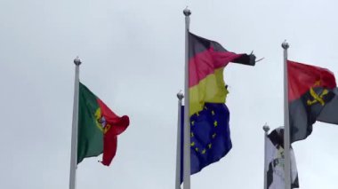 Gökyüzüne karşı farklı ülkelerin bayrakları: Portekiz, Avrupa Birliği, Almanya, Angola.