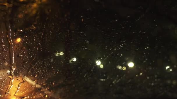 Lluvias fuertes en la calle de la noche en la gran ciudad. Vista a través del parabrisas húmedo del coche en la carretera . — Vídeo de stock