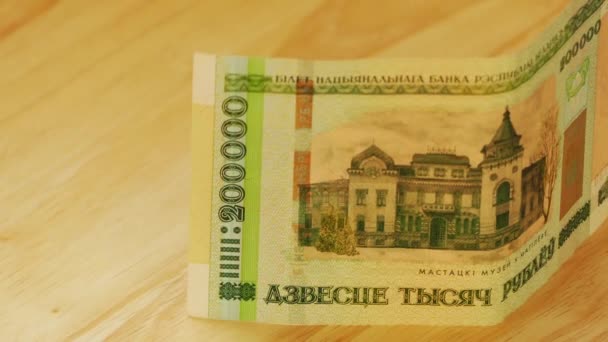 Wit-Russische roebel nominale waarde tweehonderdduizend liggen op houten tafel. — Stockvideo