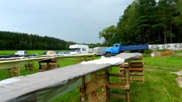 Acampamento turístico com tendas coloridas na borda da floresta de verão . — Vídeo de Stock