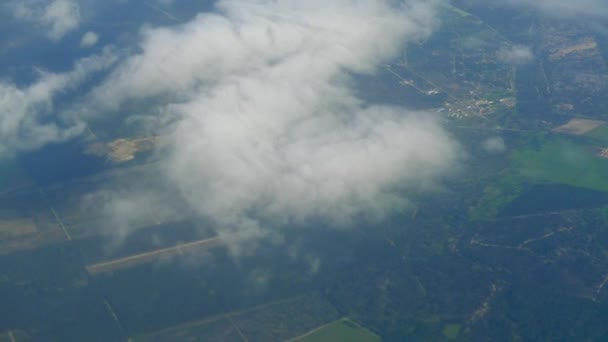 Vue de la terre et des nuages depuis la fenêtre de l'avion . — Video