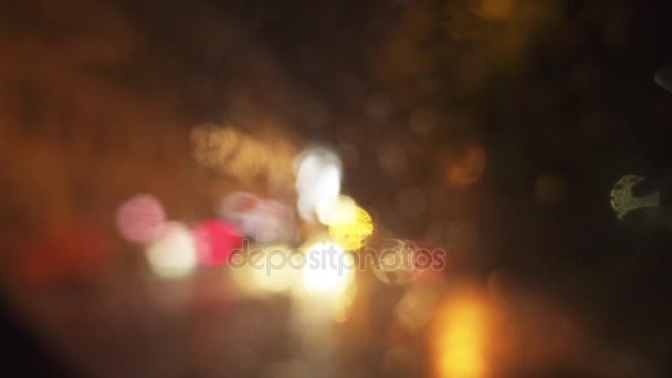 Heavy rain pours on evening street in big city. View through wet windshield of car on road. — Stock Video