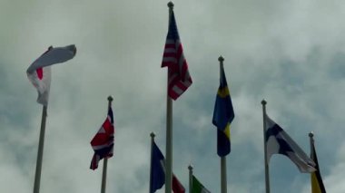 Gökyüzü karşı farklı ülkelerin bayrakları: ABD, İngiltere, Finlandiya, Japonya, Fransa, İsveç, İtalya.