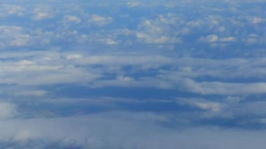 Dünya ve bulutlar uçak penceresinden görünümü.