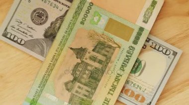 Belarus ruble par değeri 200 bin yalan ve ABD Doları (Amerikan Doları) üzerinde ahşap masa.