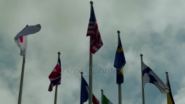 Bandeiras de diferentes países contra o céu: EUA, Grã-Bretanha, Finlândia, Japão, França, Suécia, Itália . — Vídeo de Stock