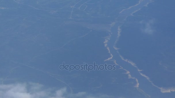 Vista de la tierra y las nubes desde la ventana del avión . — Vídeo de stock