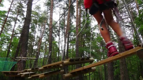 Petite fille dans le parc d'aventure. Parc d'aventure est un endroit qui peut contenir une grande variété d'éléments, tels que des exercices d'escalade de corde, parcours d'obstacles et tyroliennes. Ils sont destinés aux loisirs .
