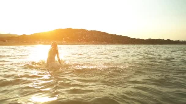 Slow Motion: Mooie meisje speelt in de golven van de zee van de warme zomer. — Stockvideo