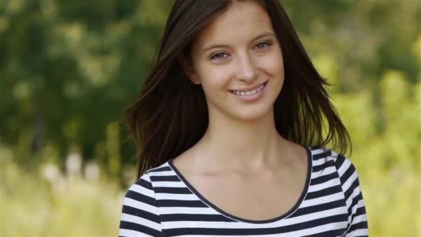 本を読んで、夏の公園の緑と美しい若い笑顔の女性. — ストック動画