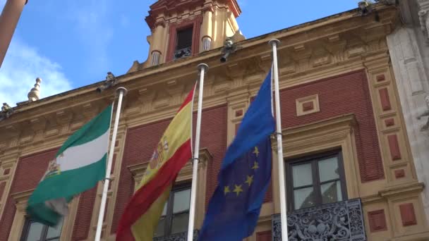 Bandera de España. Vista general del Palacio de San Telmo, en 2010 después de la restauración por el arquitecto Guillermo Vázquez Consuegra. Sevilla es la capital y la ciudad más grande de Andalucía, España . — Vídeo de stock