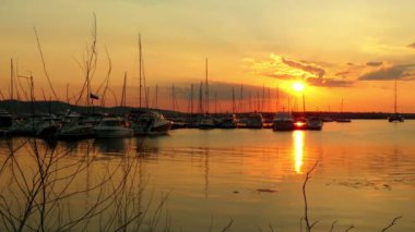 Akşam marina port Sozopol, Bulgaristan. Yatlar ve günbatımı fonunda gemi.