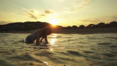 Ağır çekim: Küçük güzel kız sıcak yaz denizin dalgaları çalış..