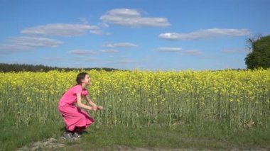 Ağır çekim: güzel küçük kız neşeyle yaz şehir Park arka plan günbatımı karşı kadar atlama.