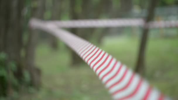 Gestreept rood-witte tape waarschuwt voor gevaarlijk gebied met beperkte toegang. — Stockvideo