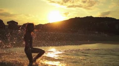 Ağır çekim: Küçük güzel kız sıcak yaz denizin dalgaları çalış..