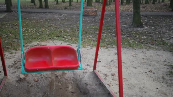 Balanço de plástico vermelho no parque infantil . — Vídeo de Stock