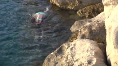 Küçük güzel kız taştan Hırvatistan Adriyatik sahil üzerinde denize atlama.